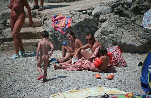 Nudists sunbathe on a beach